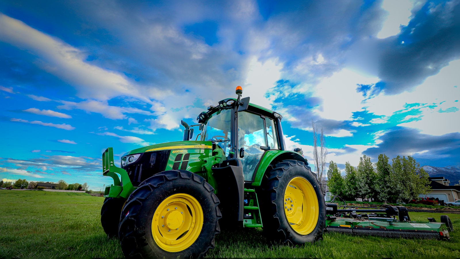 a tractor parked in a field with a blue sky in the background